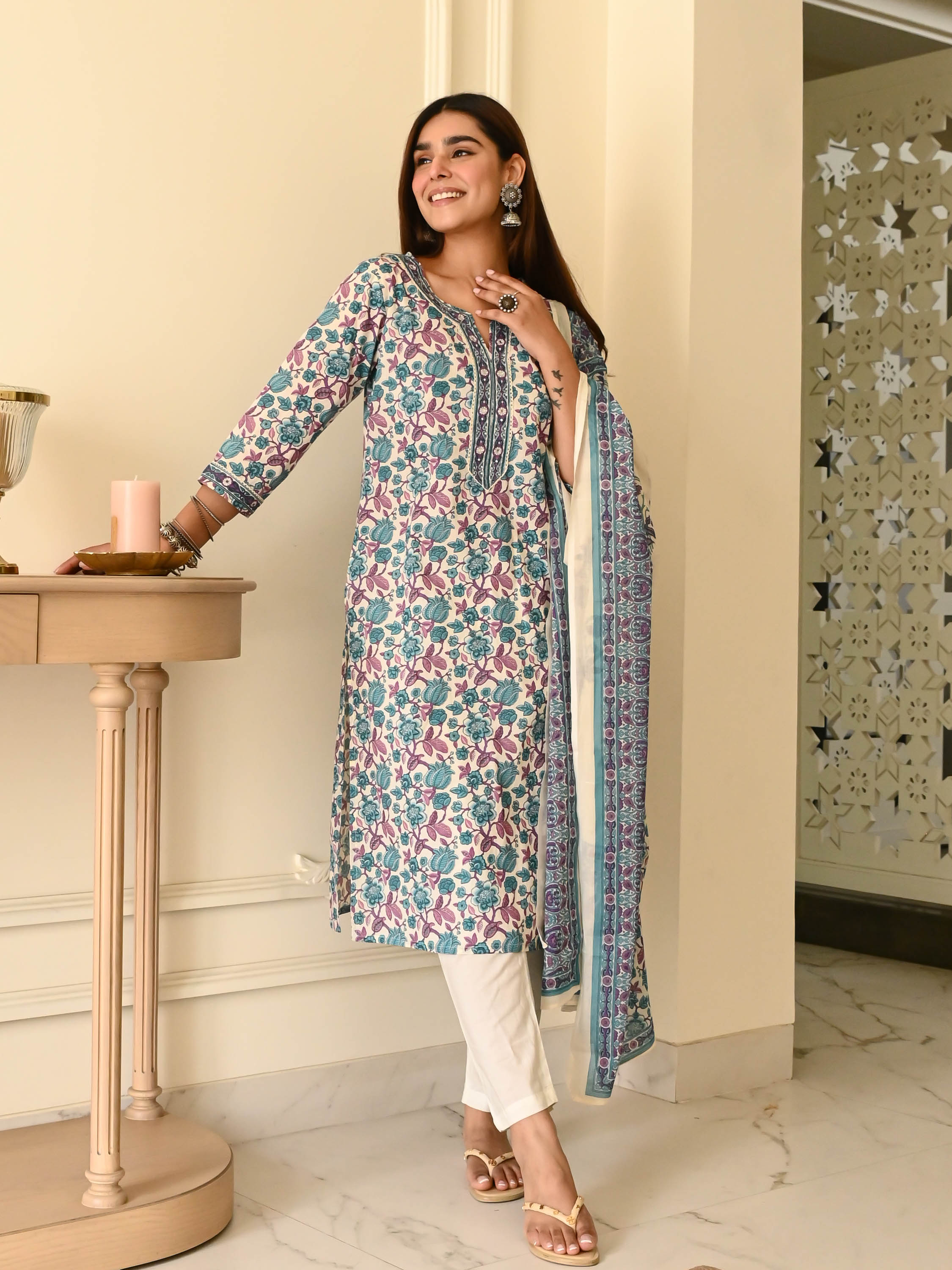 Woman in a white and blue floral printed kurta set with matching dupatta.